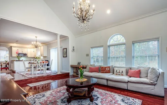a living room with furniture a chandelier and a table