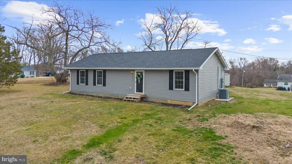 a view of a house with backyard and trees