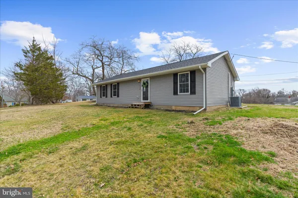 a living room with stainless steel appliances kitchen island granite countertop furniture and a refrigerator
