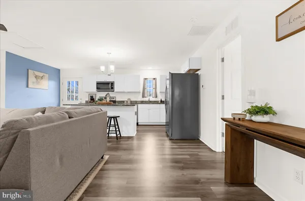 a living room with furniture kitchen view and a refrigerator