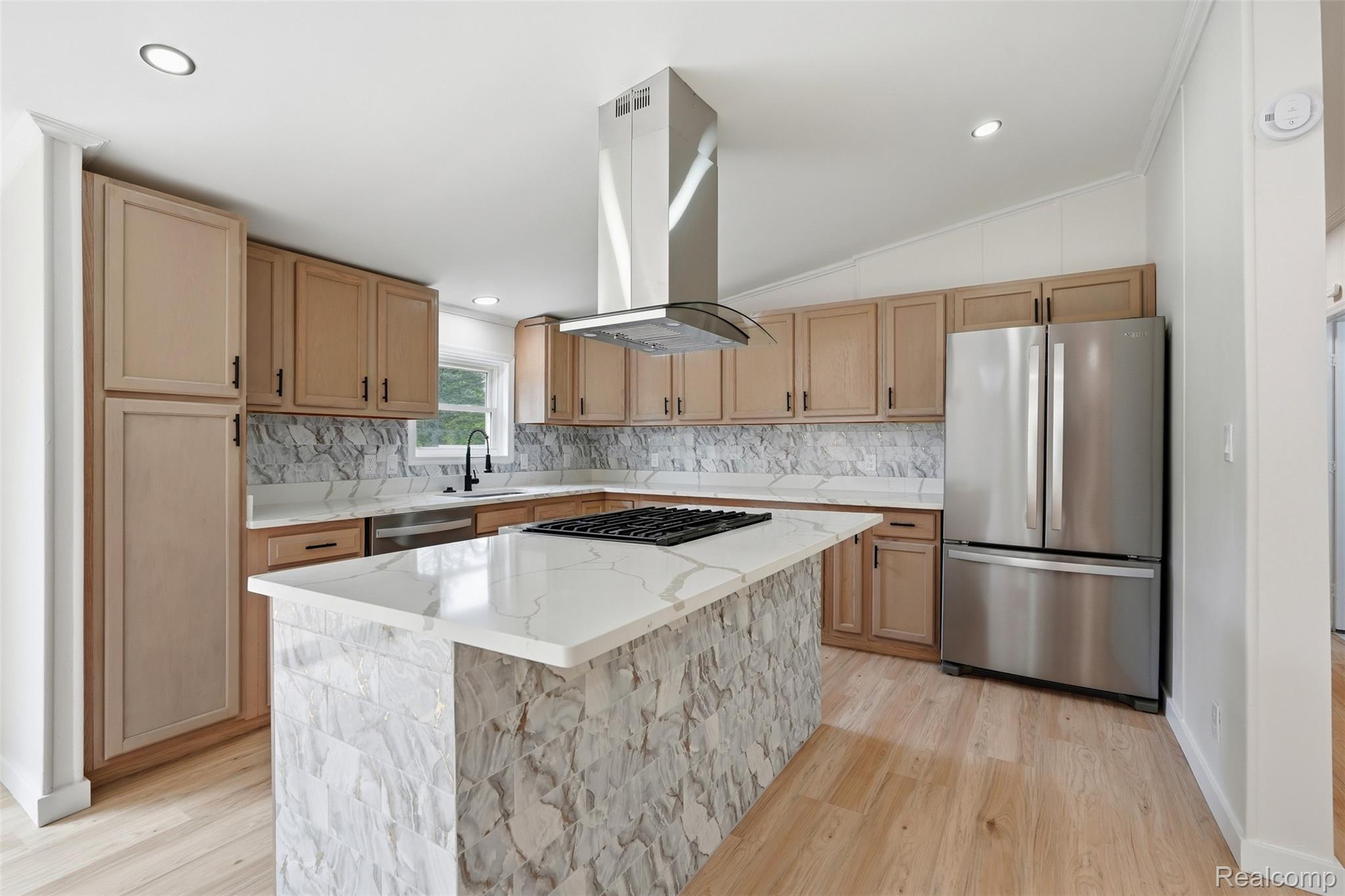 4420 Dublin Road Burton, MI 48529 - Photo 10 of 56 Kitchen featuring a central island with a gas cooktop, natural wood cabinetry, quartz countertops, a stone-finish backsplash, and stainless steel appliances