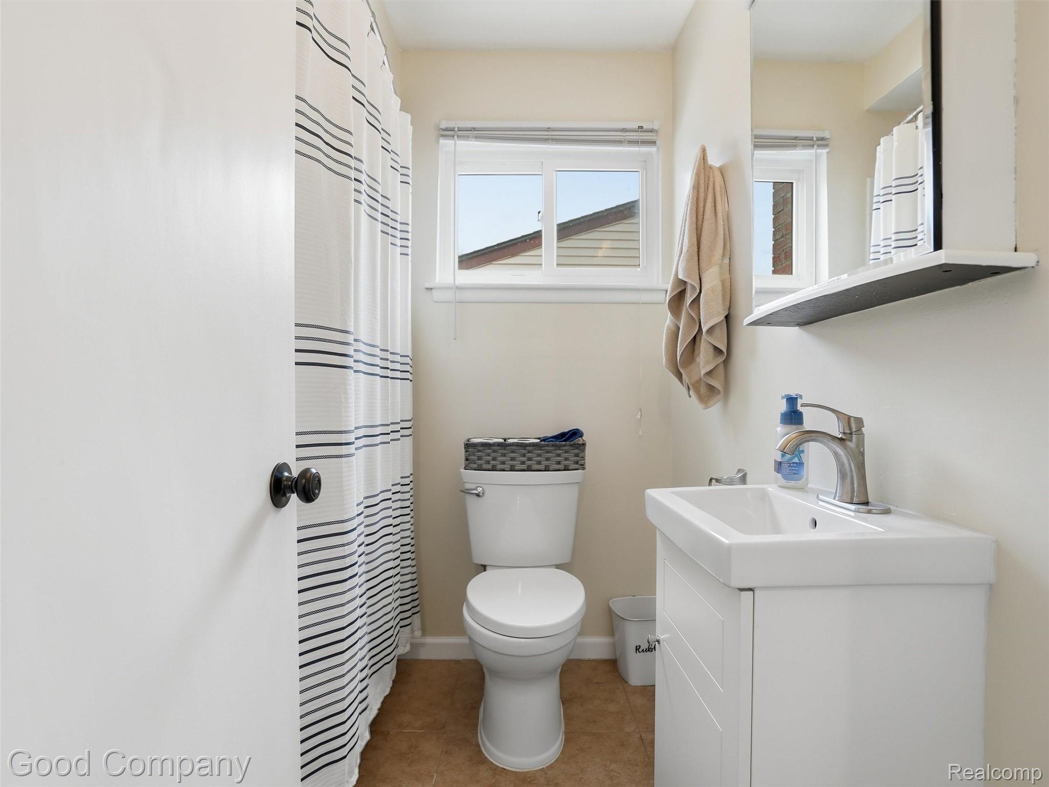 30632 Hayes Road Roseville, MI 48066 - Photo 18 of 32 Bathroom featuring a white vanity with integrated rectangular sink, a polished chrome single-handle faucet, a toilet, an opaque window with blinds, and tiled flooring