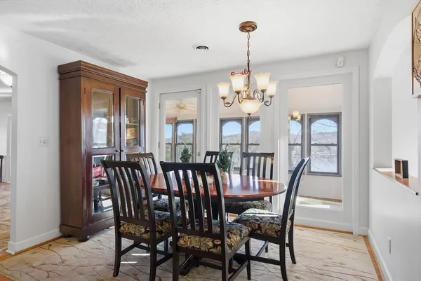 a view of a dining room with furniture a chandelier and wooden floor
