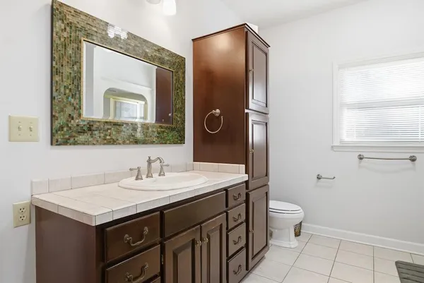 a bathroom with a toilet sink and mirror