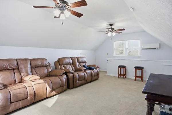 a living room with furniture a ceiling fan and a rug