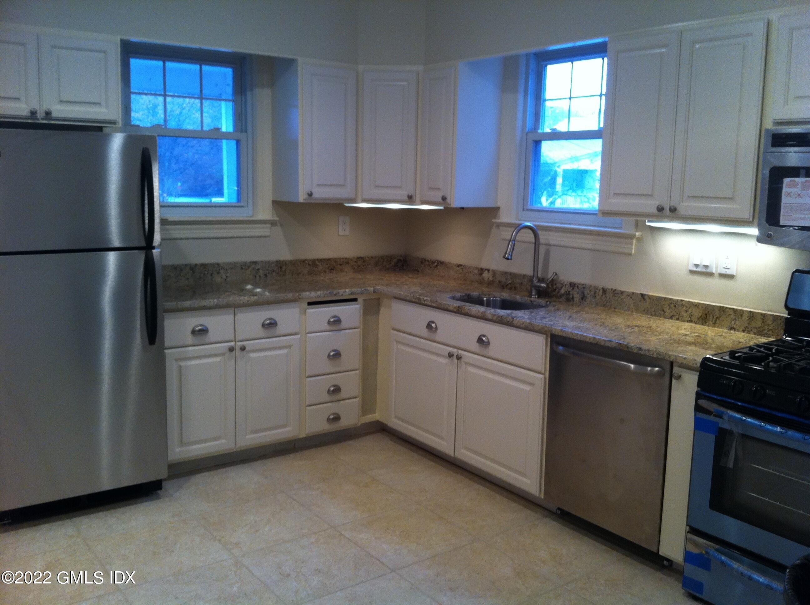84 Pemberwick Road Greenwich, CT 06831 - Photo 7 of 12 a kitchen with granite countertop cabinets stainless steel appliances a sink and a window