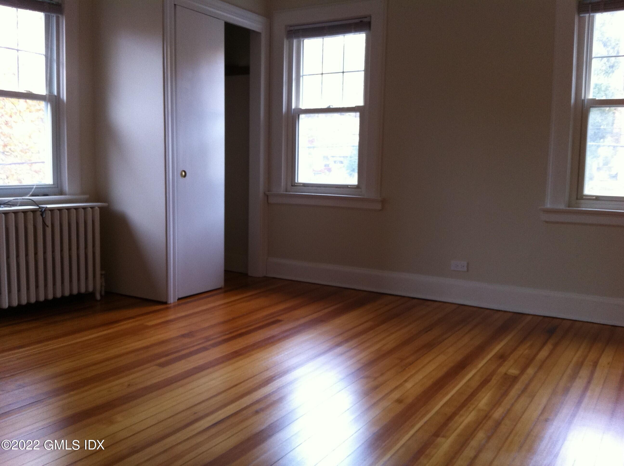 84 Pemberwick Road Greenwich, CT 06831 - Photo 8 of 12 an empty room with wooden floor and windows