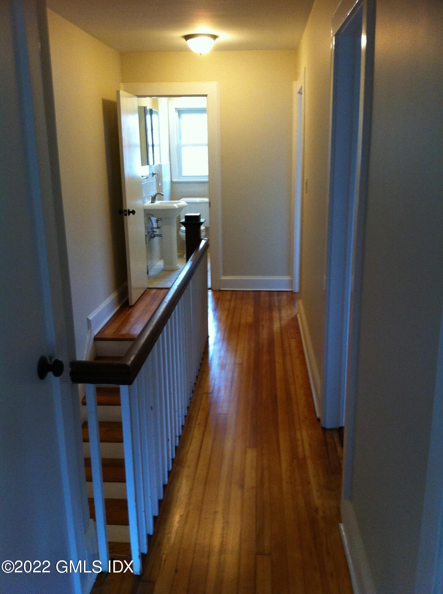 84 Pemberwick Road Greenwich, CT 06831 - Photo 9 of 12 a view of a hallway with wooden floor and staircase