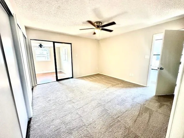 a view of an empty room and a ceiling fan view
