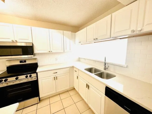 a kitchen with granite countertop a sink and a stove