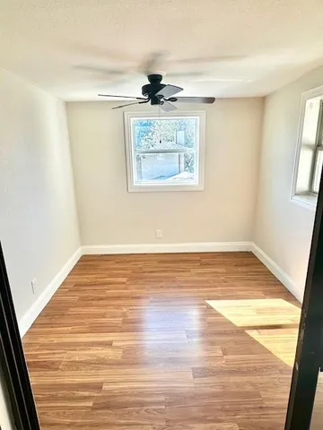 a view of a room with wooden floor and white walls