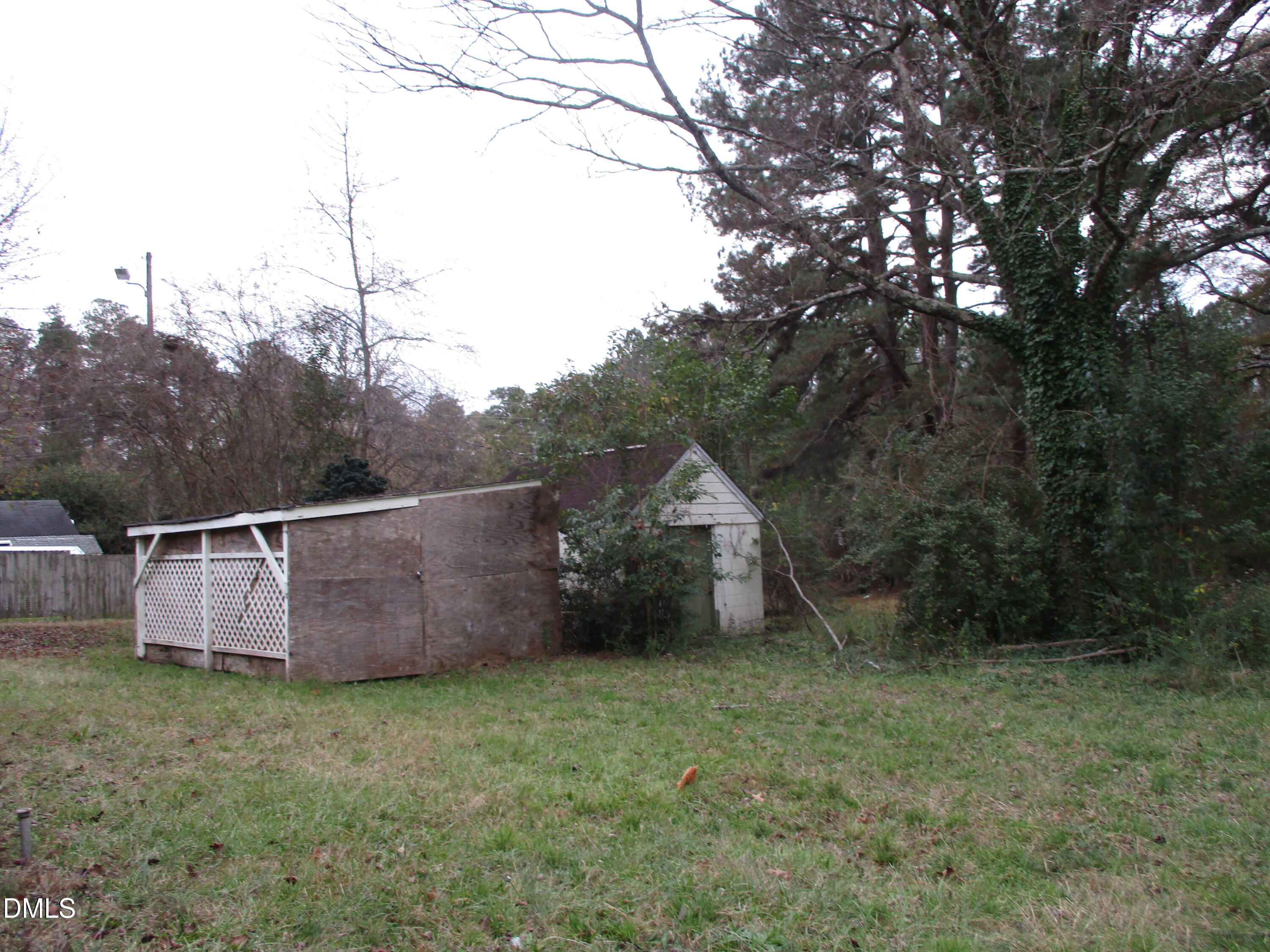 2526 Poole Road Raleigh, NC 27610 - Photo 3 of 5 a view of a backyard with potted plants and large trees