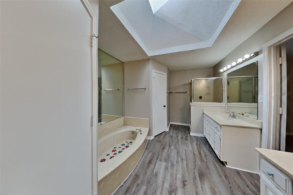 1906 Lavaca Trail Carrollton, TX 75010 - Photo 17 of 31 a bathroom with a sink a mirror and a bathtub