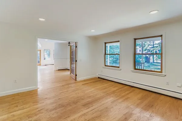 an empty room with wooden floor and windows