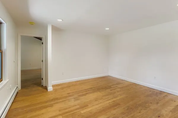 an empty room with wooden floor and door