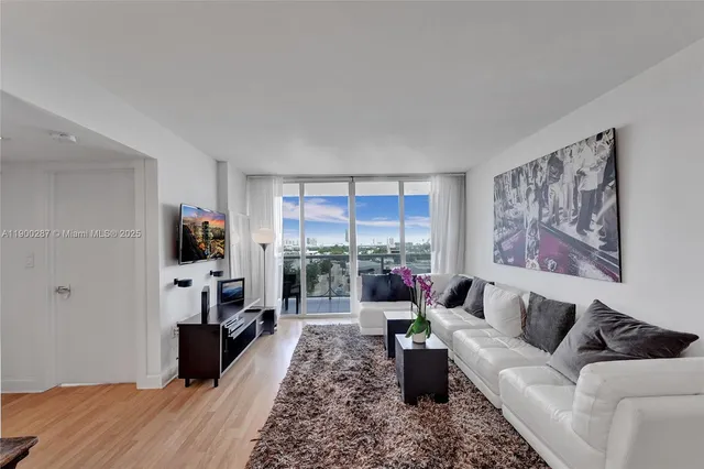 a living room with furniture a flat screen tv and a fireplace