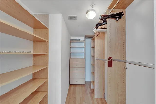 a view of walk in closet with empty racks