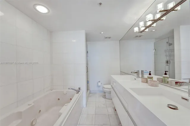 a bathroom with a tub a sink and mirror