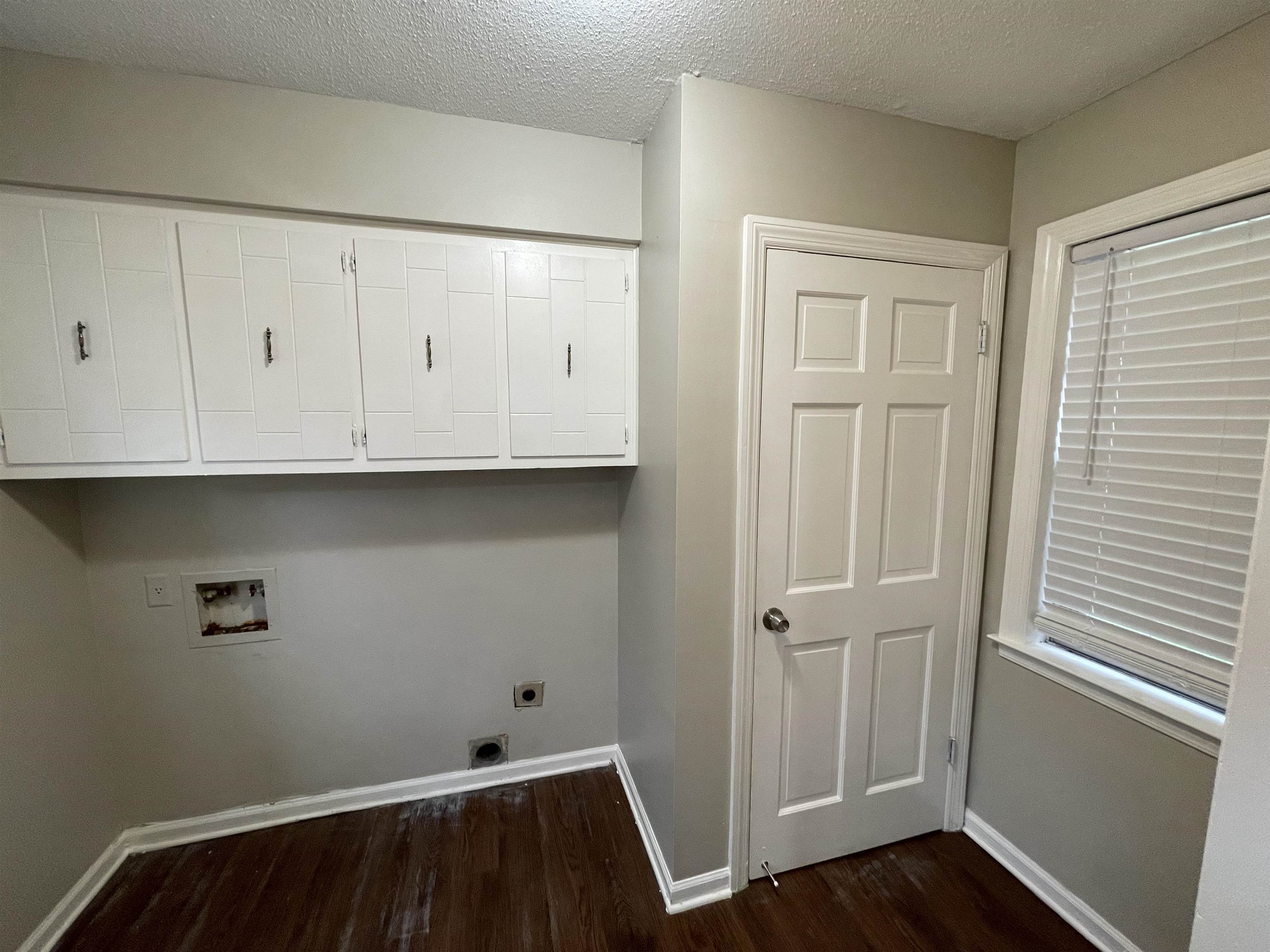 5414 Maple Ridge Road Memphis, TN 38134 - Photo 14 of 23 Clothes washing area with hookup for an electric dryer, a textured ceiling, hardwood / wood-style floors, cabinets, and washer hookup