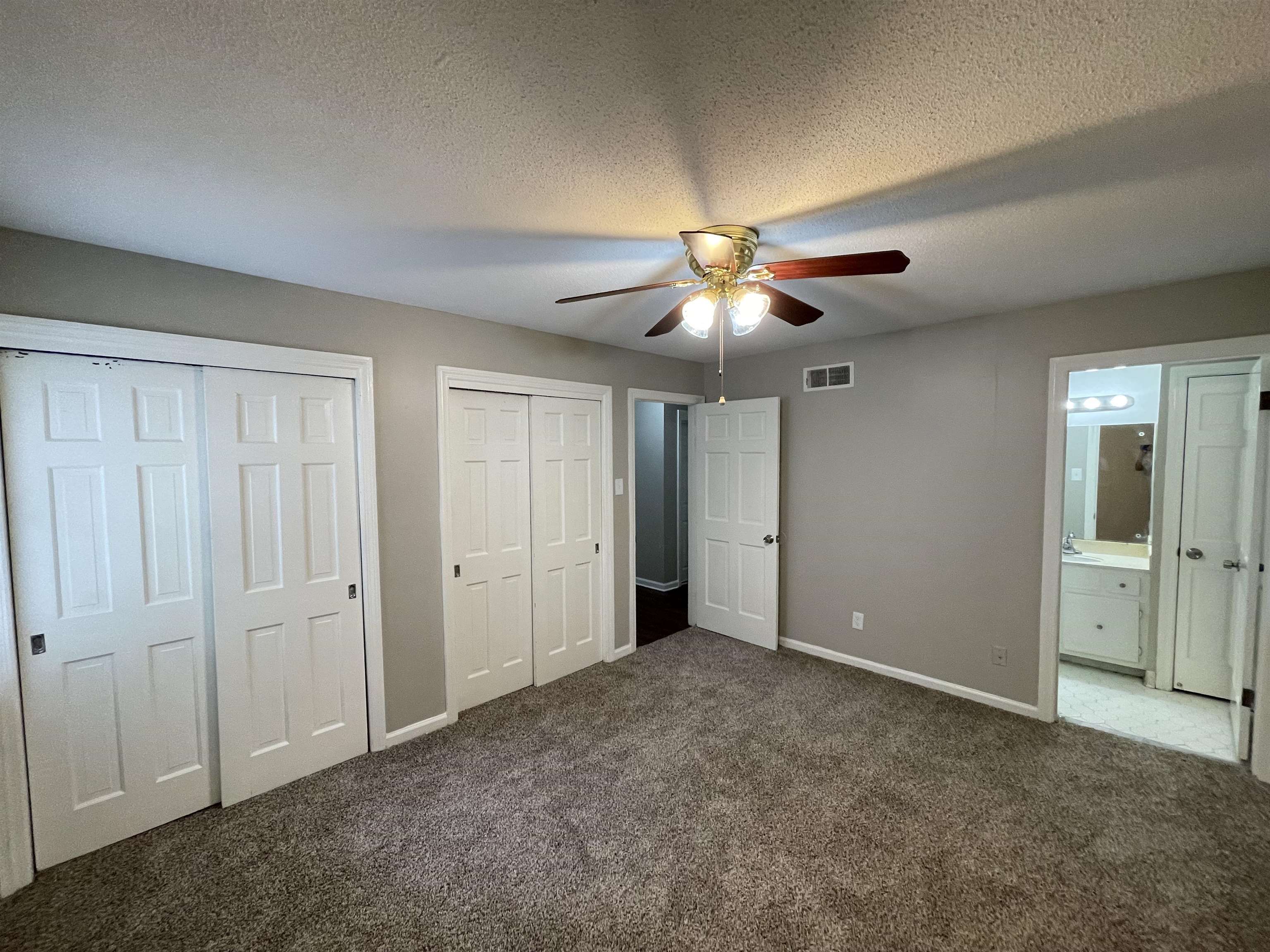 5414 Maple Ridge Road Memphis, TN 38134 - Photo 15 of 23 Unfurnished bedroom with ensuite bathroom, a textured ceiling, carpet flooring, two closets, and ceiling fan
