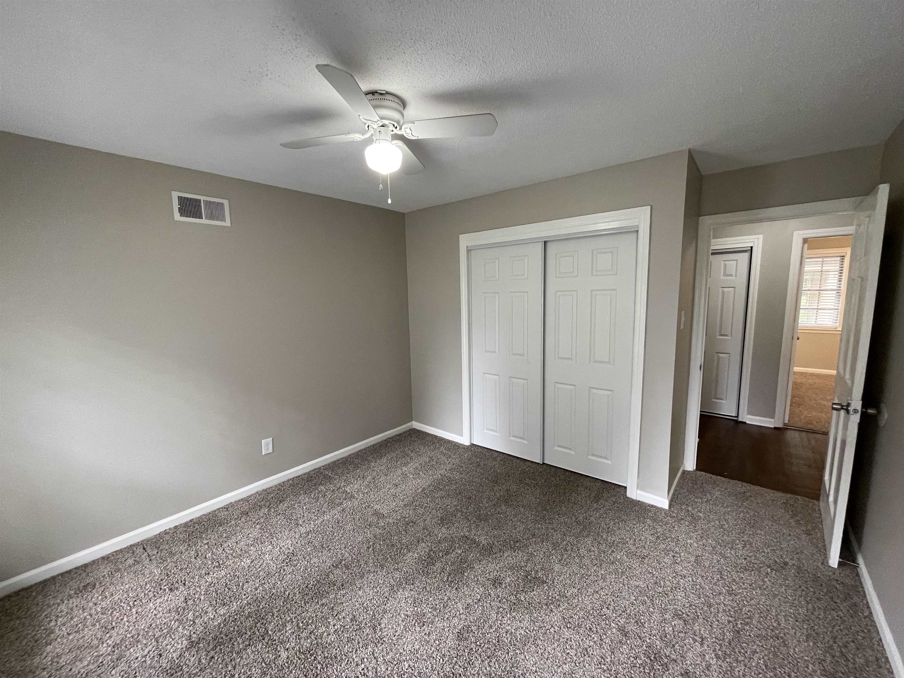 5414 Maple Ridge Road Memphis, TN 38134 - Photo 20 of 23 Unfurnished bedroom with a textured ceiling, dark carpet, a closet, and ceiling fan