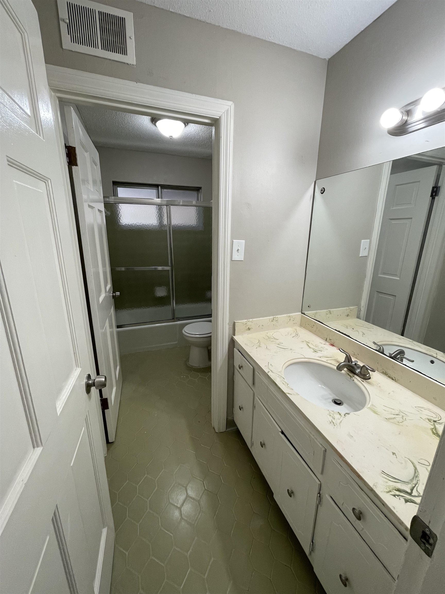 5414 Maple Ridge Road Memphis, TN 38134 - Photo 22 of 23 Full bathroom with vanity, tile patterned floors, enclosed tub / shower combo, toilet, and a textured ceiling