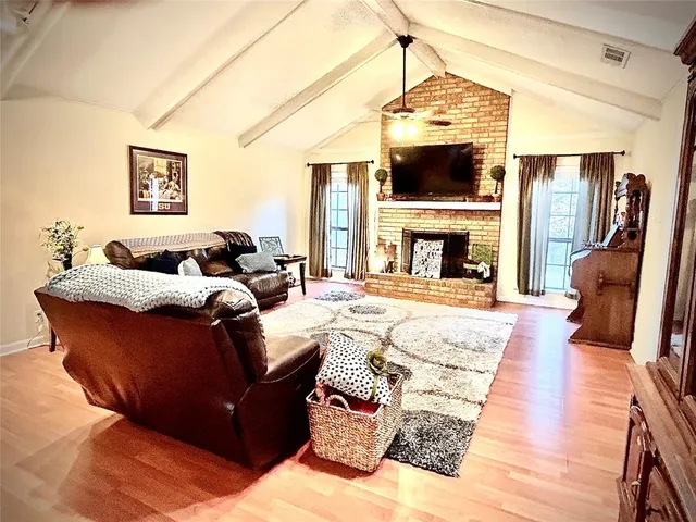 a living room with furniture a fireplace and a flat screen tv