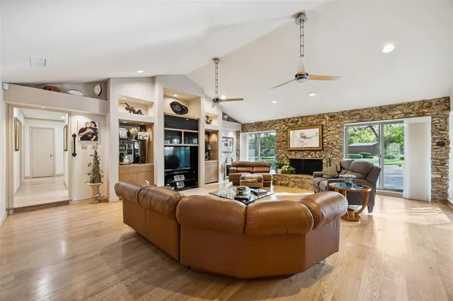 a living room with furniture a ceiling fan and a flat screen tv