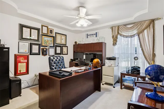 a work room with furniture a flat screen tv and a window