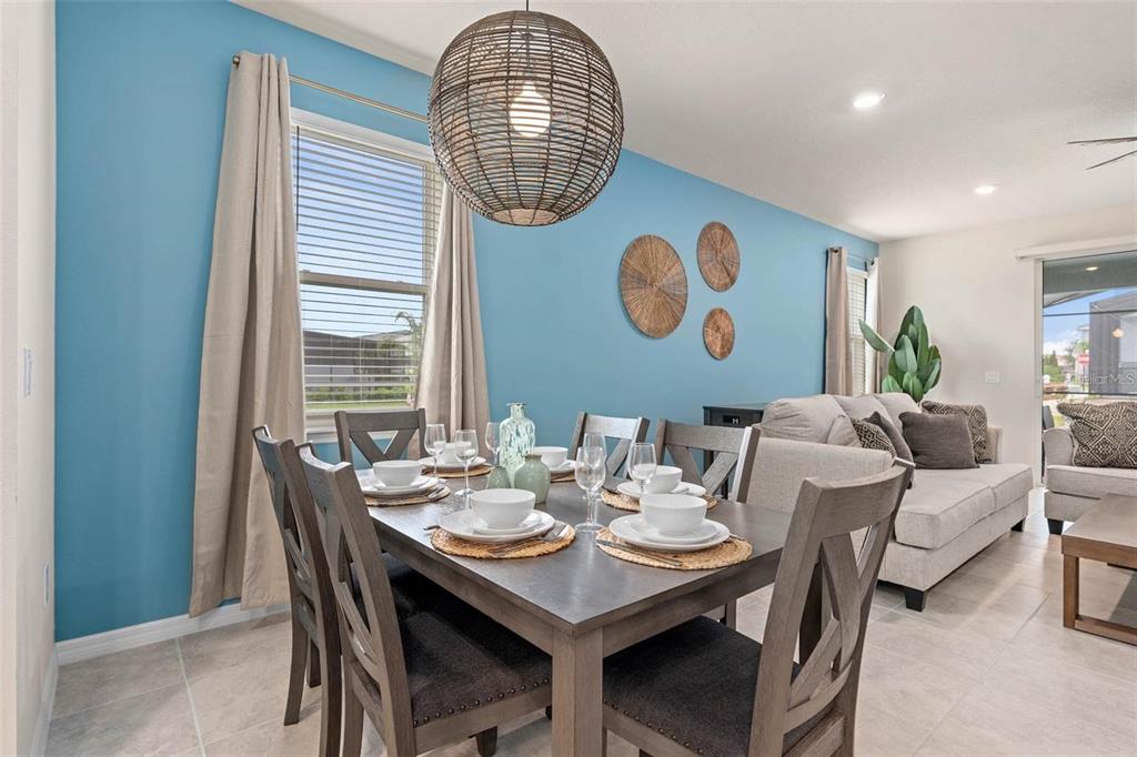 7180 Oakmoss Loop Davenport, FL 33837 - Photo 11 of 29 a view of a dining room with furniture wooden floor and a chandelier