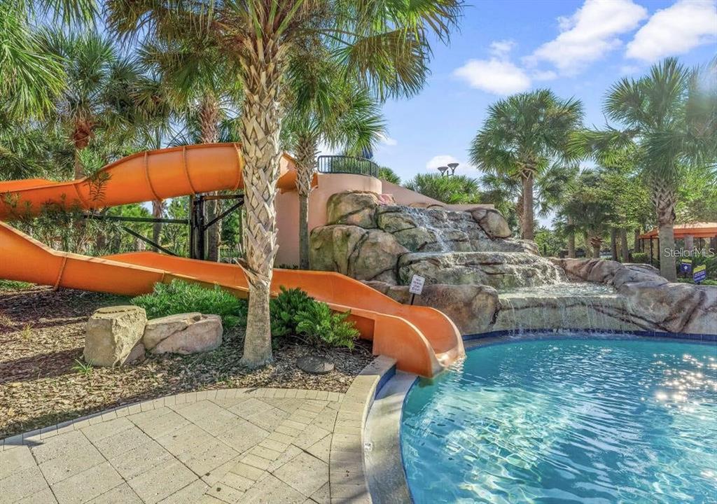 7180 Oakmoss Loop Davenport, FL 33837 - Photo 26 of 29 a view of a backyard with lawn chairs under an umbrella