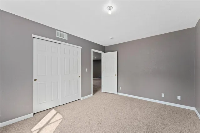 an empty room with windows and closet