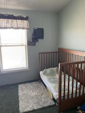 a bed sitting in a bedroom next to a window