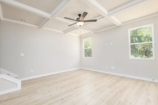 an empty room with windows and fan