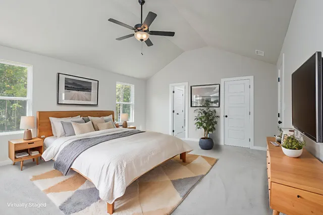 a spacious bedroom with a bed and a flat screen television