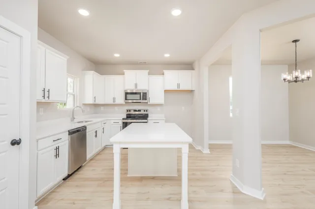 a kitchen with stainless steel appliances kitchen island granite countertop a sink and cabinets