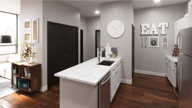 a kitchen with a refrigerator a sink and dishwasher with wooden floor