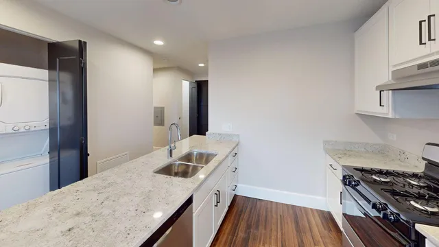 a kitchen with granite countertop a refrigerator and a sink