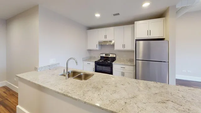 a view of a kitchen with kitchen island a large counter space a sink and appliances