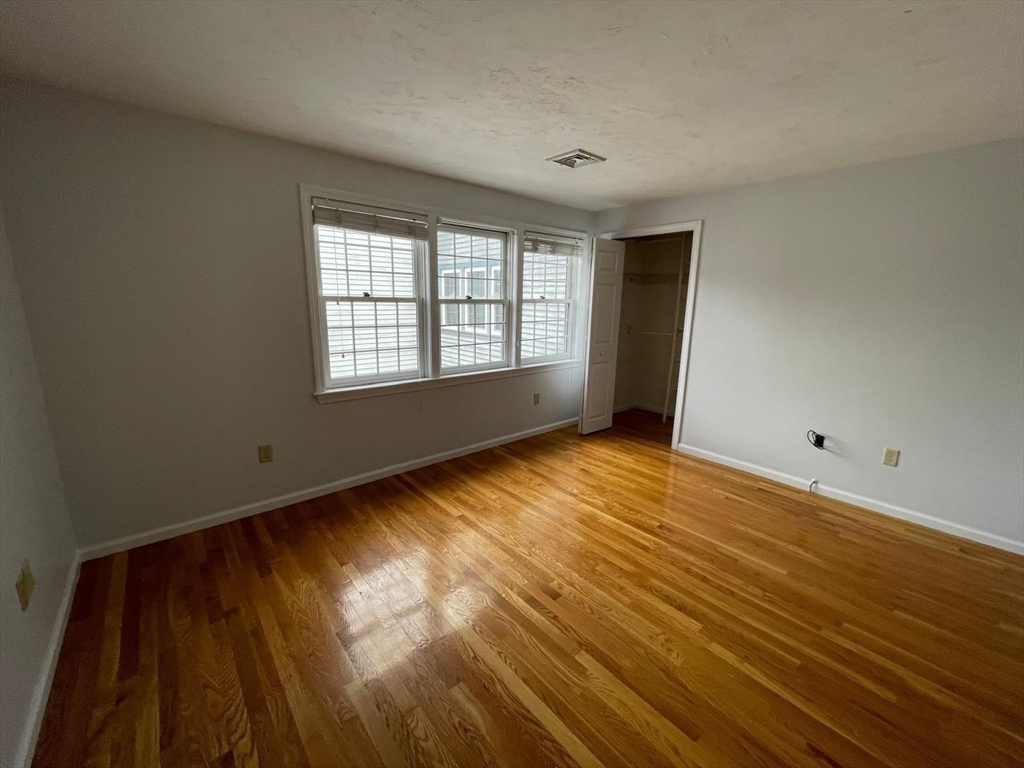 43 Merrymount Road, Unit 7 Quincy, MA 02169 - Photo 18 of 21 a view of an empty room with wooden floor and a window