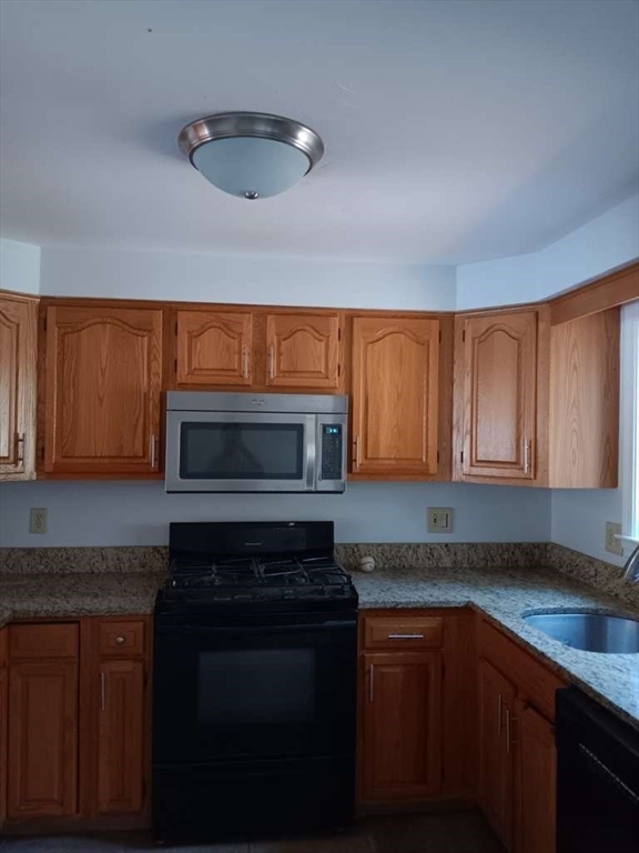 43 Merrymount Road, Unit 7 Quincy, MA 02169 - Photo 6 of 21 a kitchen with stainless steel appliances wooden cabinets and a stove top oven