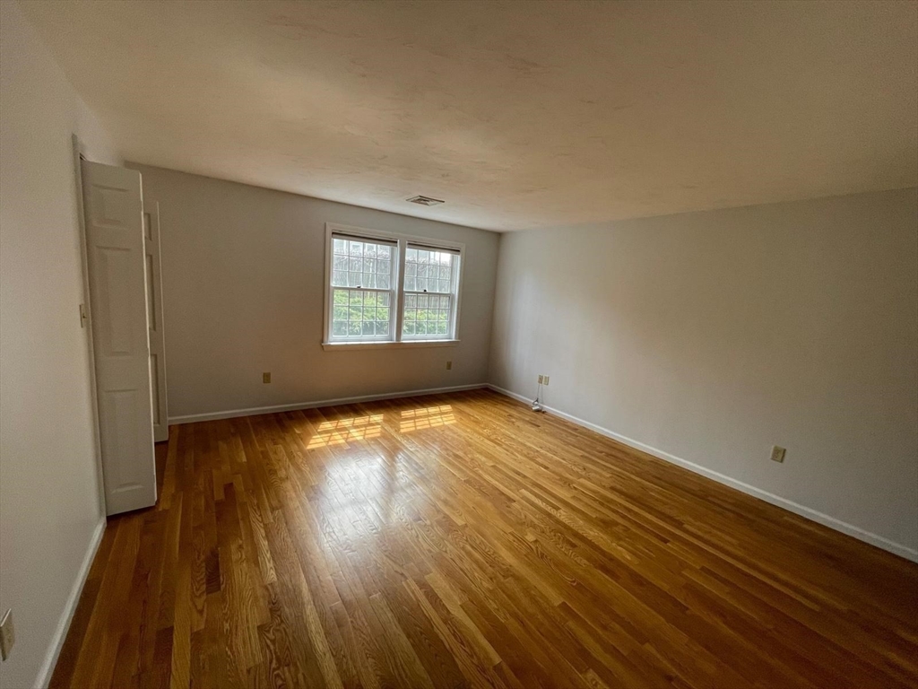 43 Merrymount Road, Unit 7 Quincy, MA 02169 - Photo 7 of 21 an empty room with wooden floor and windows