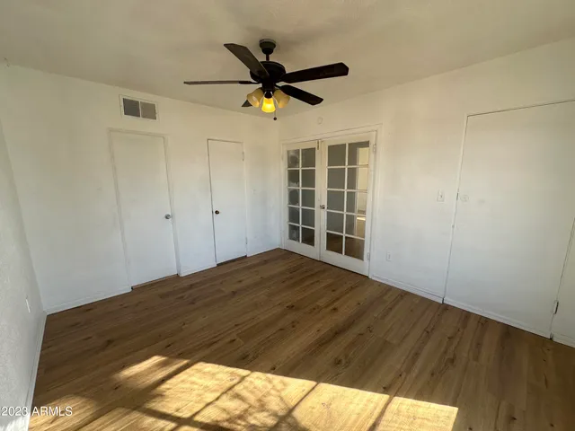 a view of a livingroom with a ceiling fan and wooden floor