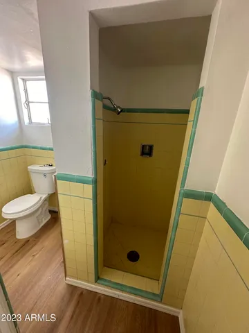 a bathroom with a granite countertop shower and a toilet