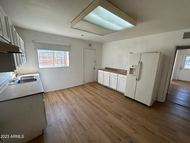 a kitchen with wooden floors and appliances