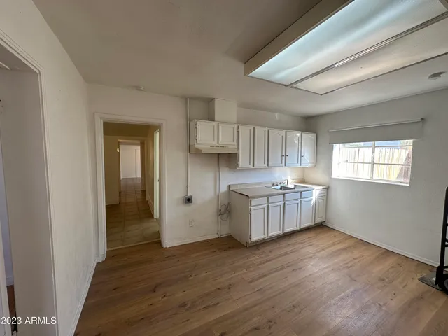 a kitchen with a sink cabinets and wooden floor