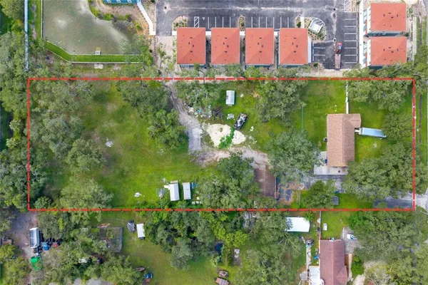 an aerial view of residential house with outdoor space and trees all around