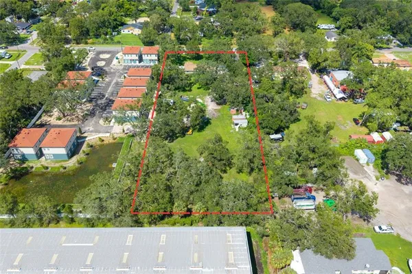 an aerial view of residential house with outdoor space and trees all around