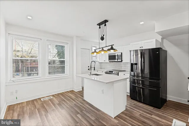 a kitchen with stainless steel appliances a sink stove and refrigerator