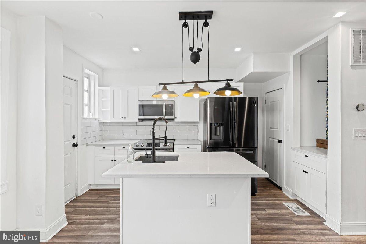 2637 Carroll Street Philadelphia, PA 19142 - Photo 10 of 31 a kitchen with stainless steel appliances a stove top oven a refrigerator and a cabinets